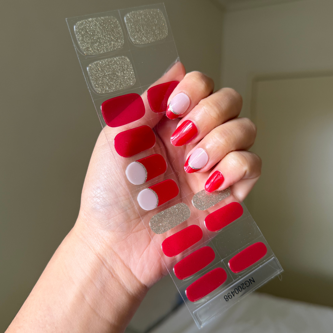 Hand holding a gellae semicured gel nail sticker sheet with silver and red french tip valentine
